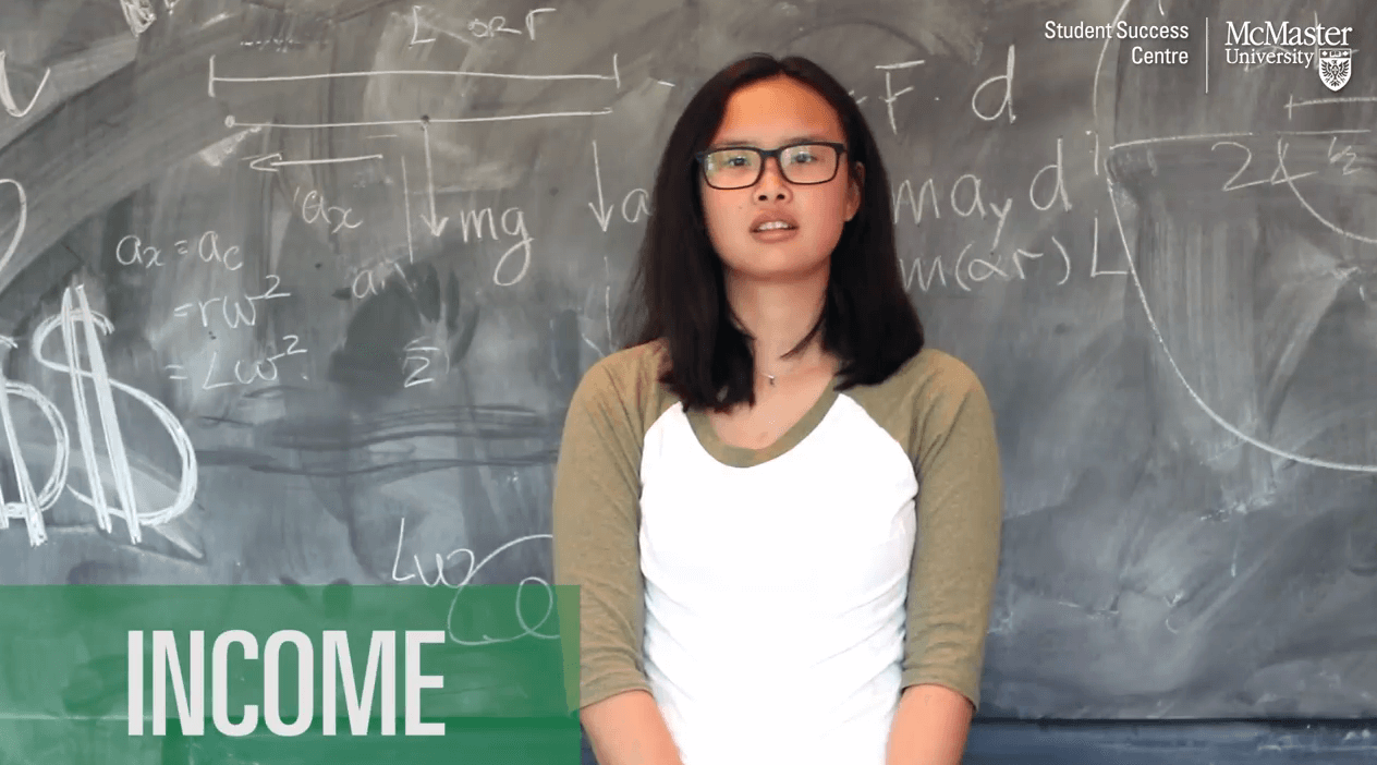 Image of student standing in-front of a chalkboard asking for words associated with the word income.